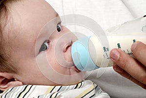 Baby drinking milk of her bottle