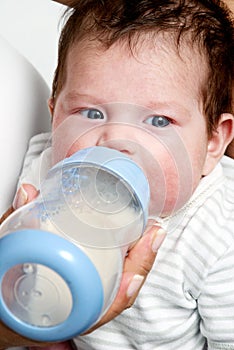 Baby drinking milk of her bottle