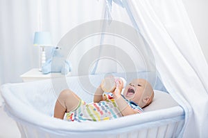 Baby drinking milk. Boy with formula bottle in bed