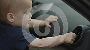 baby driver sitting inside daddy's car pushing buttons dashboard exploring board