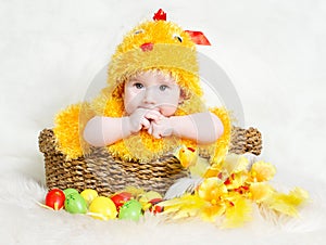 Baby in Easter basket with eggs in chicken hat