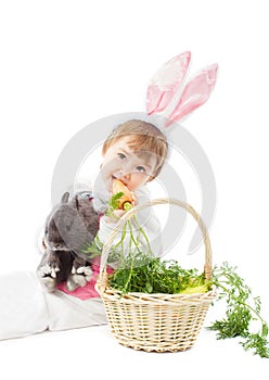 Baby in easter bunny costume eating carrot, kid girl rabbit hare