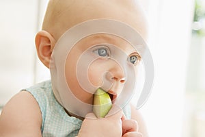 Baby eating apple indoors