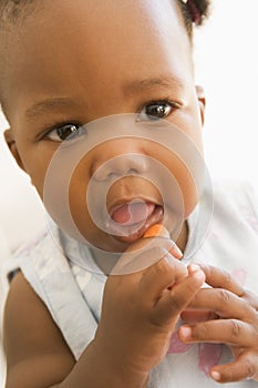 Baby eating carrot