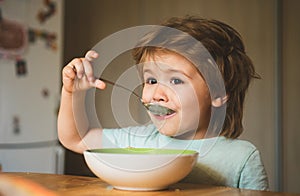 Baby eating. Food and Drink for Child. The child in the kitchen at the table eating. Happy baby boy eats healthy food