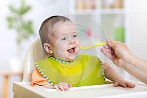 Baby eating food on kitchen