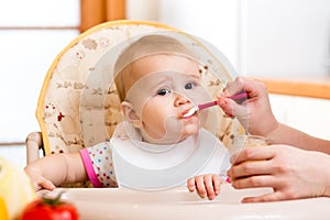 Baby eating food on kitchen