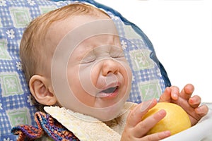 Baby eating lemon on isolated background