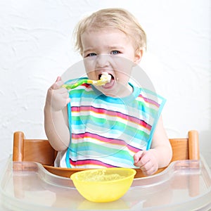 Baby eating porridge from bowl