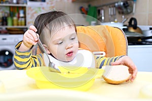 Baby eating soup and bread
