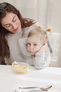 Baby eating from tupperware with mother