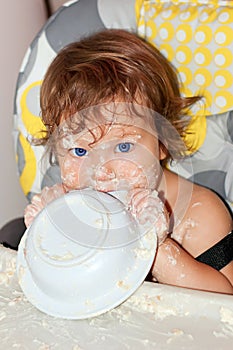Baby eating yogurt and soiled face