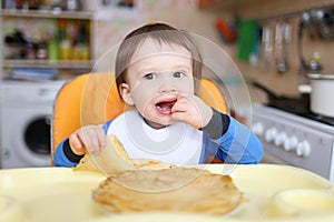 Baby eats pancakes