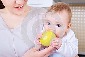 Baby eats yellow apple.Child photo