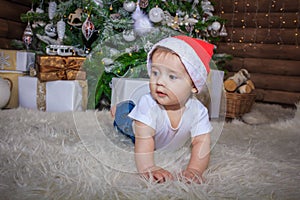 Baby in elf costume playing with old wooden train and soft toy bears under the Christmas tree, vintage.