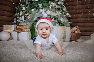 Baby in elf costume playing with old wooden train and soft toy bears under the Christmas tree, vintage.