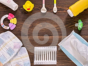 Baby essentials and care on dark wooden table with copy space