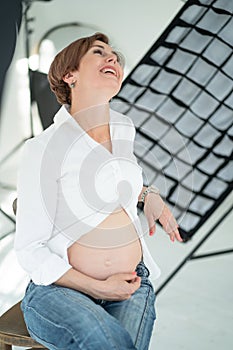 Baby Expectation Happiness. Pregnant Mom Laughs At The Camera.