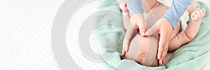 Baby face massage banner with copy space. Masseuse or mother gently stroking baby boy face with both hands. Close up.