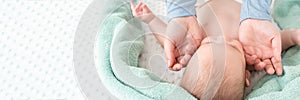 Baby face massage banner with copy space. Masseuse or mother gently stroking baby boy face with both hands. Close up cropped shot.