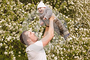 Baby with faher in the park in the rays of sunset. Toddler on the nature outdoors. Backlight. Summertime family scene