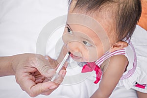 Baby feeding with liquid medicine with a syringe