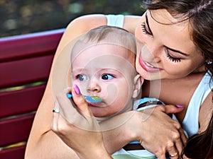 Baby feeding spoon by mother in park outdoor. Weaning .