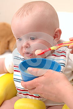 Baby feeding on sweet potatoes