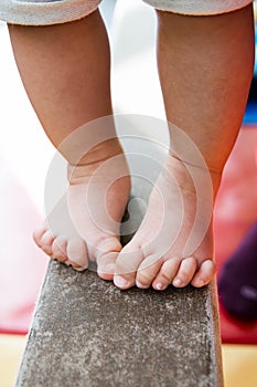 Baby feet balancing on balance beam