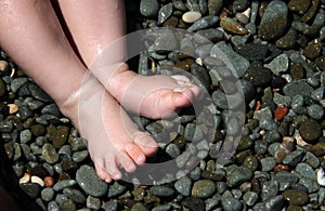 Baby feet on beach pebble