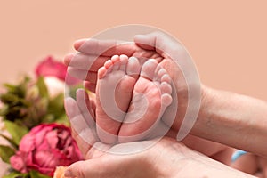 Baby feet cupped into mothers hands.