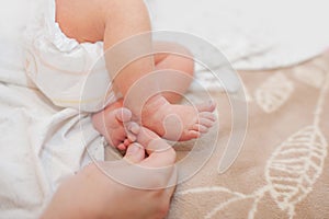 Baby feet cupped into mothers lovely hands with soft focus on babie`s foot