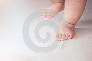 Baby feet doing the first step on the floor