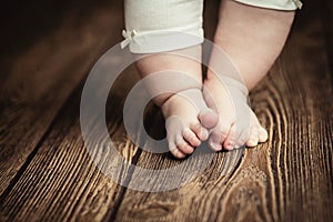 Baby feet doing the first steps. Baby`s first steps. Baby feet .