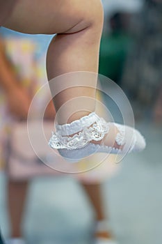 Baby feet dressed in white thin socks close up