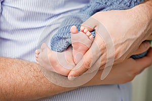 Baby feet in father hands. Tiny Newborn Baby's feet