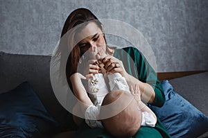 Baby feet in the hands of the mother. Mom and her baby. The concept of a happy family. A beautiful conceptual image of