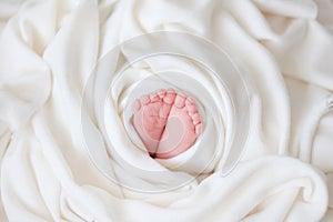 Baby feet in the hands of parents, Newborn baby feet in white cloth wrapped in heart, baby life