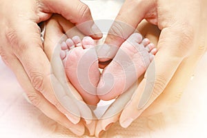 Baby feet in mother and father`s hands. My parents and their child. Happy Family concept. Beautiful conceptual image