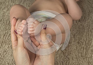 Baby feet in mother hands. Happy Family concept