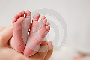 Baby feet in mother hands. Mom and her Child. Happy Family concept.