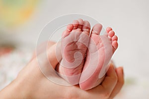 Baby feet in mother hands. Mom and her Child. Happy Family concept.