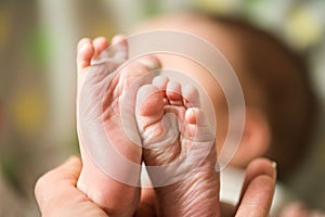 Baby feet in mother hands. Mom and her Child. Happy Family concept. Beautiful conceptual image of Maternity