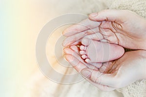 Baby feet in mother hands. Mom and her Child. Happy Family concept. Beautiful conceptual image of Maternity