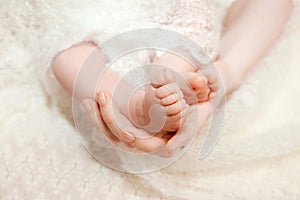 Baby feet in mother hands. Mom and her child. Happy family concept. Beautiful conceptual image of Maternity