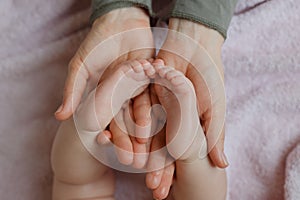 Baby feet in mother hands. Mom and her Child. Masseur massaging little baby`s foot. Happy Family concept.