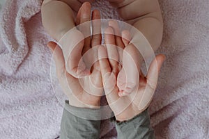 Baby feet in mother hands. Mom and her Child. Masseur massaging little baby`s foot. Happy Family concept.