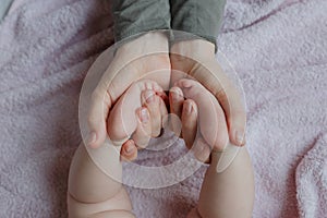 Baby feet in mother hands. Mom and her Child. Masseur massaging little baby`s foot. Happy Family concept.