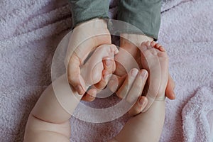 Baby feet in mother hands. Mom and her Child. Masseur massaging little baby`s foot. Happy Family concept.