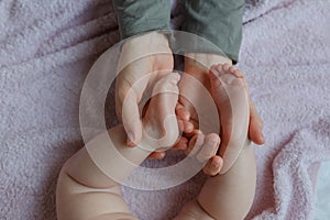 Baby feet in mother hands. Mom and her Child. Masseur massaging little baby`s foot. Happy Family concept.